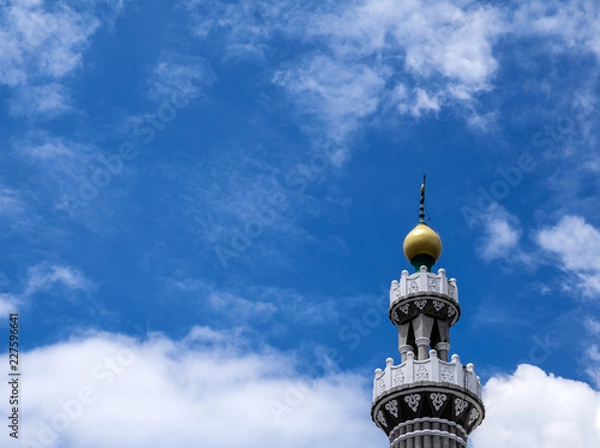 Fototapeta Top of mosque building in sunny day. Low angle view to a beautiful top roof of mosque, Orthodox architecture design, high tower in middle east Asia style. Muslim church, a place to worship.