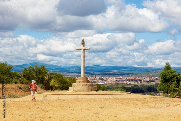 Fototapeta Camino de Santiago (Spain) - The Santo Toribio stone cross and a pilgrim walking along the way of St.James, near Astorga