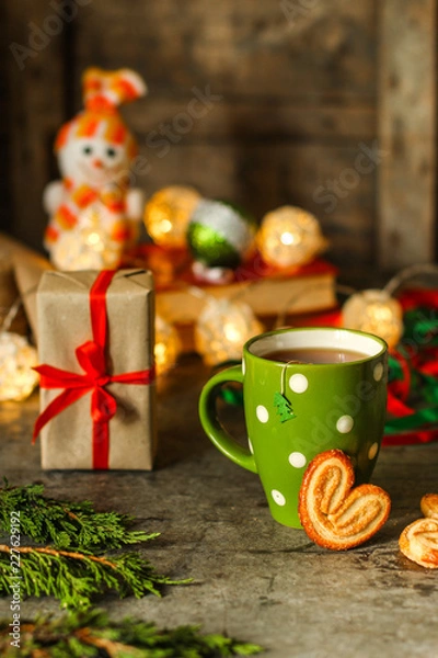 Fototapeta tea - a cup of tea and gifts for the new year. Brewed tea bag. a cup on the table and a festive atmosphere. top view.