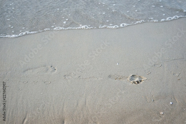 Obraz background backdrop from sand, footprints  and water  on the beach