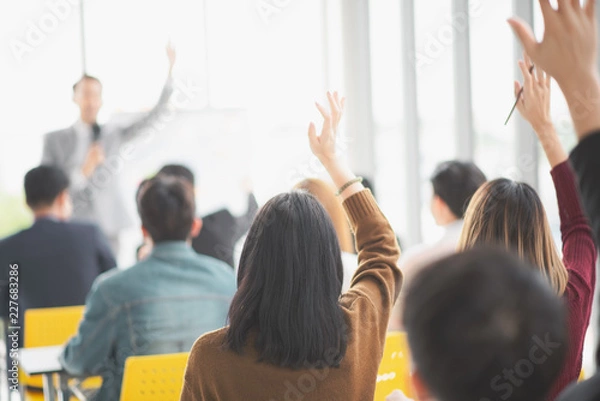 Fototapeta Seminar group raising up hand for asking the speaker that allow to raising up hand in question and answer time in meeting room back side