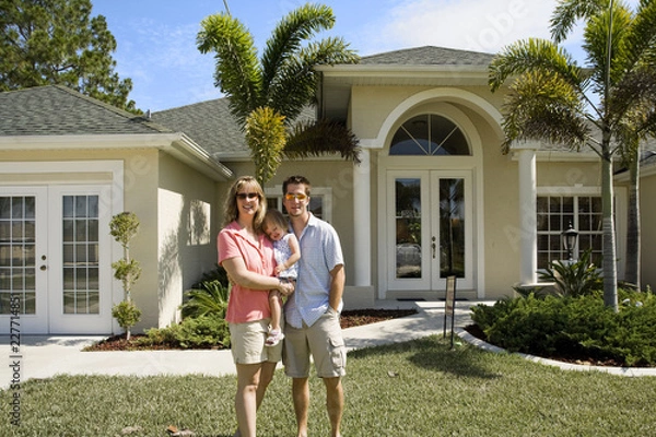 Obraz happy couple standing in front of their house