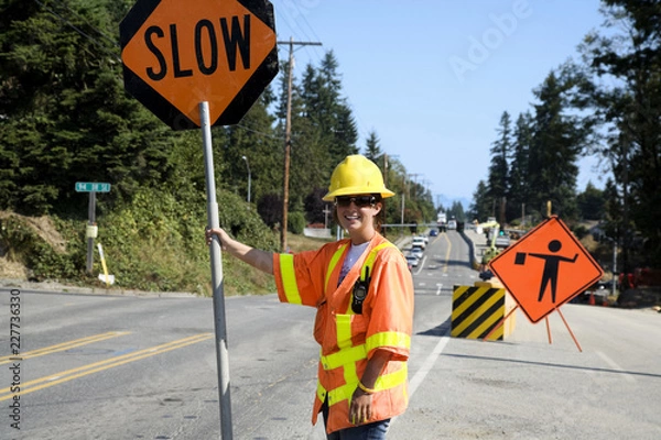 Obraz construction worker with stop sign on road
