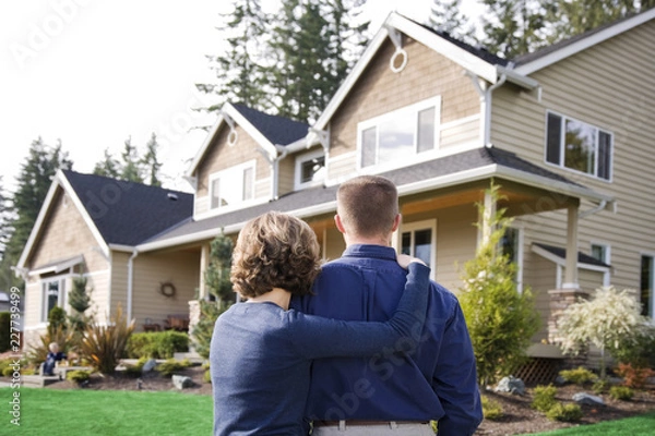 Obraz happy couple in front of house in front of new house
