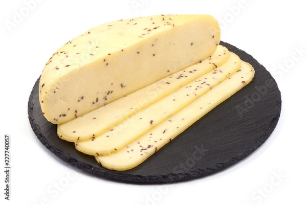 Fototapeta Sliced Cheese with cumin seeds on a slate shale plate, isolated on a white background.