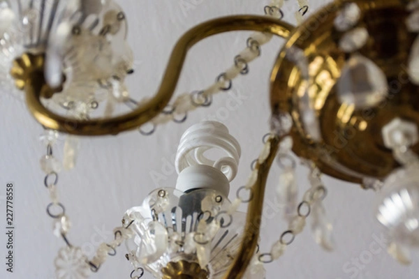 Fototapeta Energy saving lamp in an old vintage chandelier