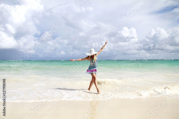 Fototapeta Young slim beautiful woman dancing  on the beach, playful, dancing, running, summer dream vacation, sunny, having fun, positive mood,  splashing water, happy 