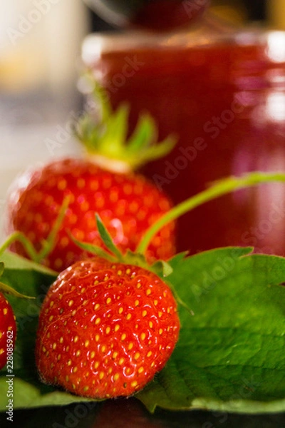 Obraz Erdbeeren vor einem Marmeladenglas