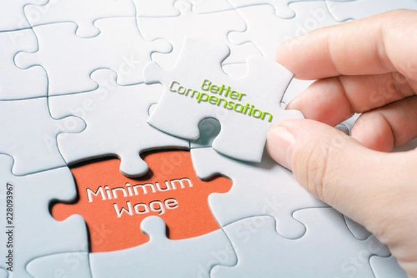Fototapeta The Words Minimum Wage And Better Compensation In Missing Piece Jigsaw Puzzle