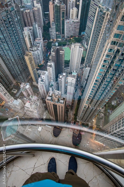 Obraz Widok ze szklanej windy na miasto i wieżowce, przyprawiający o zawrót głowy widok z góry na nowoczesne miasto