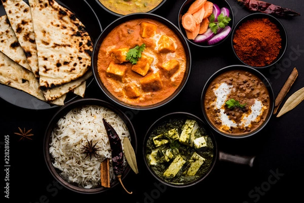 Fototapeta Indian Lunch / Dinner main course food in group includes Paneer Butter Masala, Dal Makhani, Palak Paneer, Roti, Rice etc, Selective focus