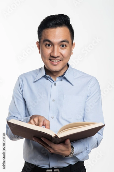 Obraz Asian man reading book looking for answer