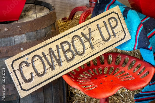 Fototapeta Wystrój w stylu zachodnim z napisem Cowboy up i pomalowanym na czerwono siedzeniem traktora