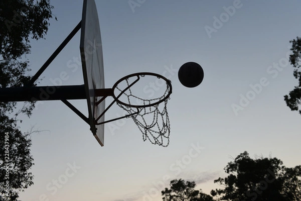 Fototapeta Silhouette of a basketball hoop and backboard at sunset