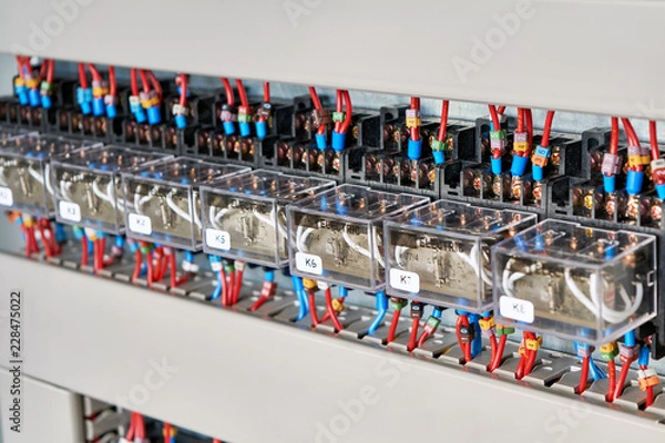 Fototapeta A range of electrical intermediate relays in an electrical Cabinet. The wires are connected to the relay by means of tips and marked according to the project. Production automation.