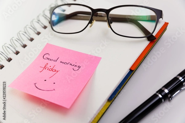 Fototapeta Good morning Friday, written on a post it glued to a notepad with glasses on top. 