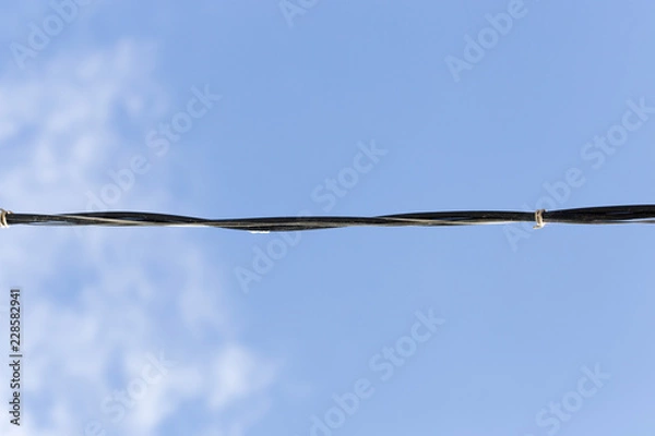 Obraz electrical wire against the bkue sky.