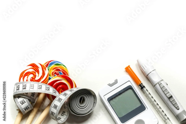 Fototapeta Sweet candy with Insulin syringe,lancet,test strip,glucose meter and lancing device concept of diabetes and reduction of eating sweets