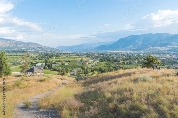 Fototapeta Walking trail on Munson Mountain with view of city of Penticton in distance in summer