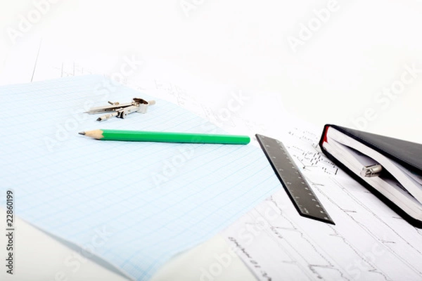 Obraz A compass on a graph paper with notepad