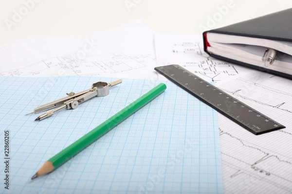 Fototapeta Compass on a graph paper with notepad