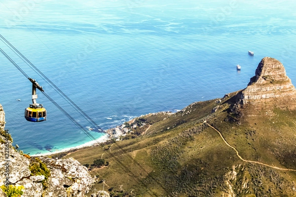 Fototapeta Top down view from Table Mountain of a cable car and the Lion's Head on the right and Atlantic Ocean in the background