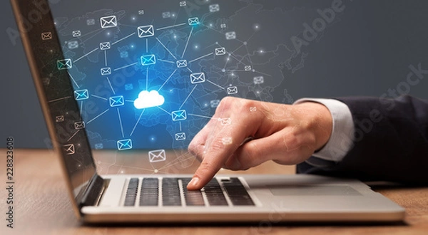 Fototapeta Businessman hand sending a bunch of messages on laptop with cloud computing concept
