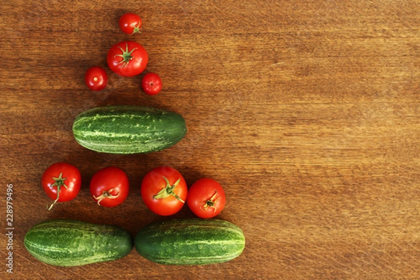 Fototapeta top view of fresh organic home grown vegetables on a brown wooden table. tomatoes, cucumbers and peas