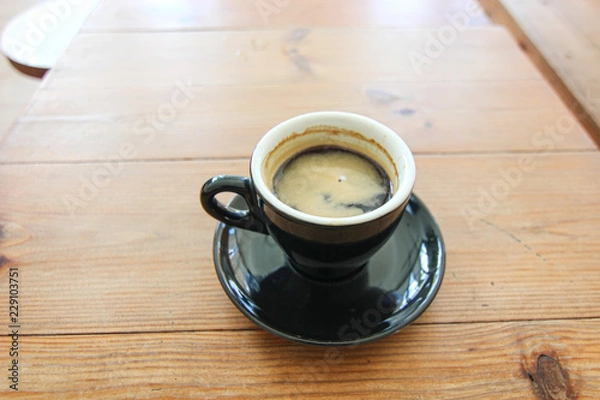Obraz Coffee cup of Espresso Americano in black mug ceramic on the soft brown wood table background