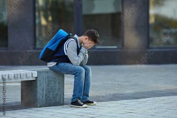 Fototapeta Schoolboy crying in the yard of the school