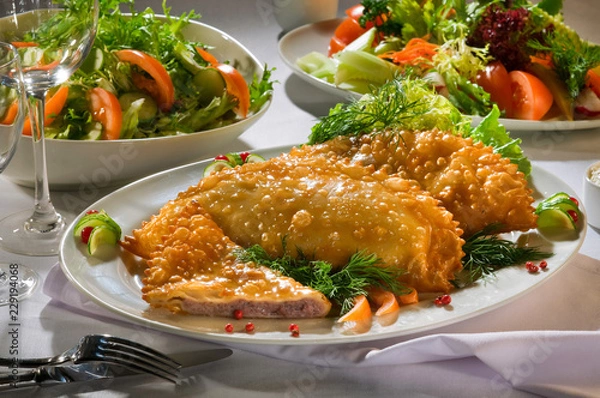 Obraz Чебуреки на белой тарелке на сервированном белом столе Chebureks on a white plate on a served white table