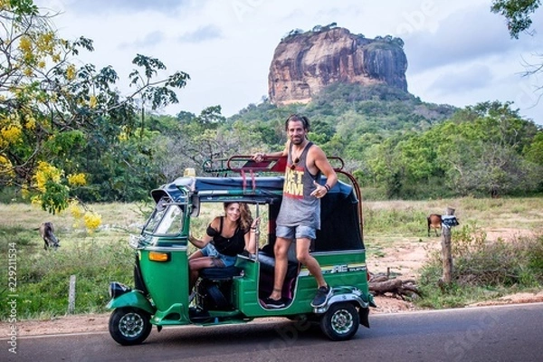 Fototapeta Deux personnes dans un Tuk-tuk au sri lanka devant le Lion Rock