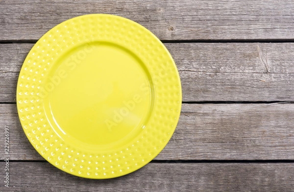Obraz Empty yellow plate on wooden table
