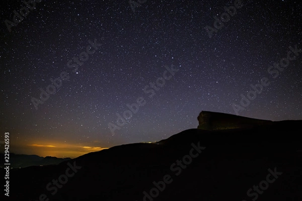 Obraz Gwiaździste nocne niebo nad górami Kaukazu Północnego. Letni wieczór o zmierzchu.