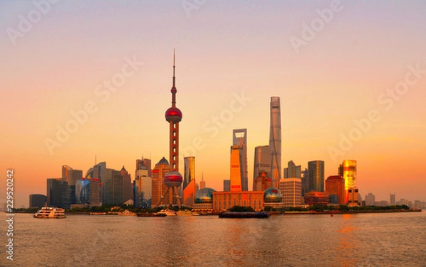 Fototapeta Cityscape and panorama of modern architecture,  warm colors and sunset on river of shanghai pudong skyline and skyscrapers, China