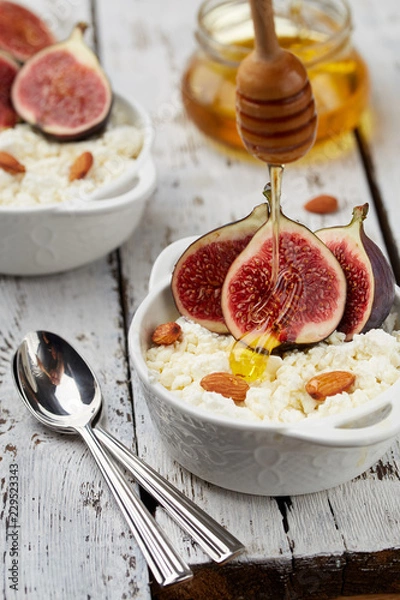 Fototapeta Cottage cheese with Figs, honey and almonds in a white bowl on a light background. Concept: healthy Breakfast