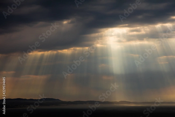 Fototapeta Dramatic cloud formations with the rays of the sun shining through at Jeffreys Bay in South Africa