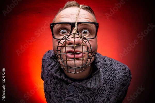 Obraz Angry and agressive man with dog muzzle basket shouting