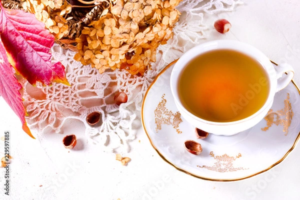 Fototapeta Tea in the rustic vintage Chic style. Garden tea Party. Teapot of dry flowers. Cup of tea with autumn decor on table, with hydrangea and pumpkin