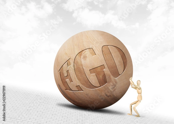 Obraz Man pushes a huge wooden ball with inscription Ego upwards along the slope. Abstract image with a wooden puppet