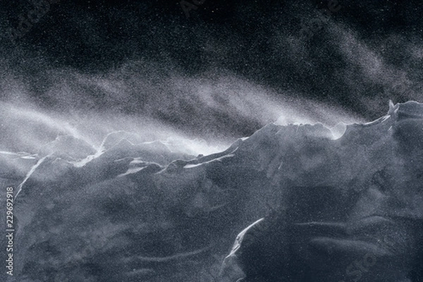 Obraz Wind blows fresh snow over an embankment