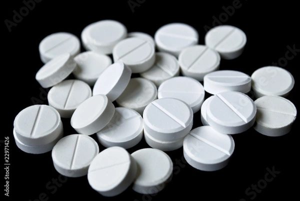 Fototapeta Scattering of white tablets on black background
