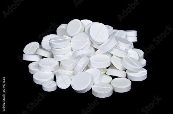 Fototapeta Pile of the white pills on the black background