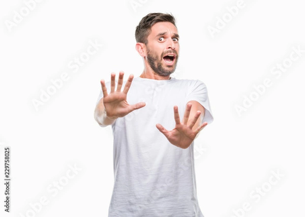 Fototapeta Young handsome man over isolated background afraid and terrified with fear expression stop gesture with hands, shouting in shock. Panic concept.