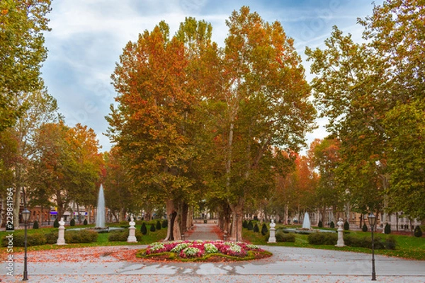 Fototapeta View of the famous Zrinjevac park in down town of Zagreb, Croatia, during autumn with statues, music pavilion, and water fountains. 