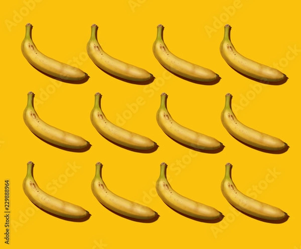 Fototapeta Banana pattern on colored background.Banana with sharp shadows on color background. Colorful poster with bananas on colored background