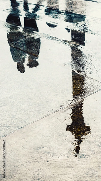 Fototapeta Reflection of couple in wet pavement front of Nelson's Column, Traflagar Square, London, UK