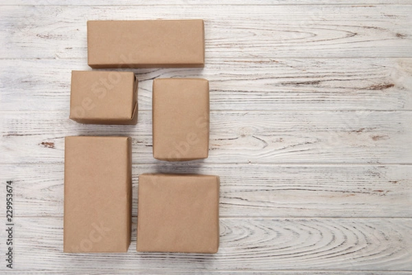 Fototapeta cardboard box on white wooden background, Brown mail package top view