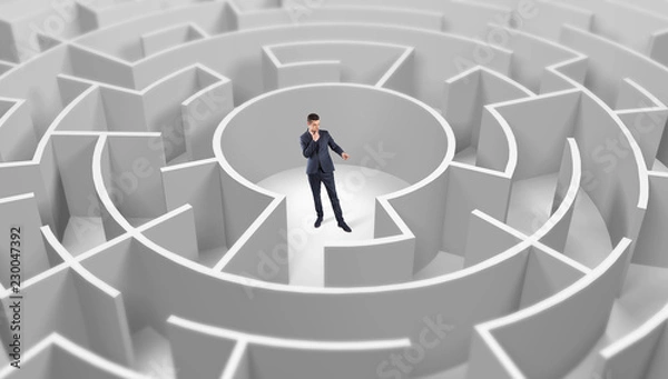 Fototapeta Young businessman standing in a middle of a 3d round maze
