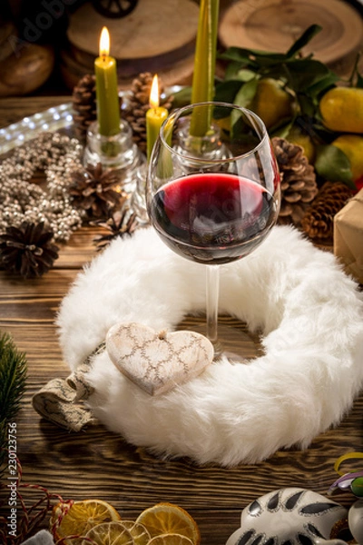 Obraz Glass of red wine on wooden table on christmas decorated background